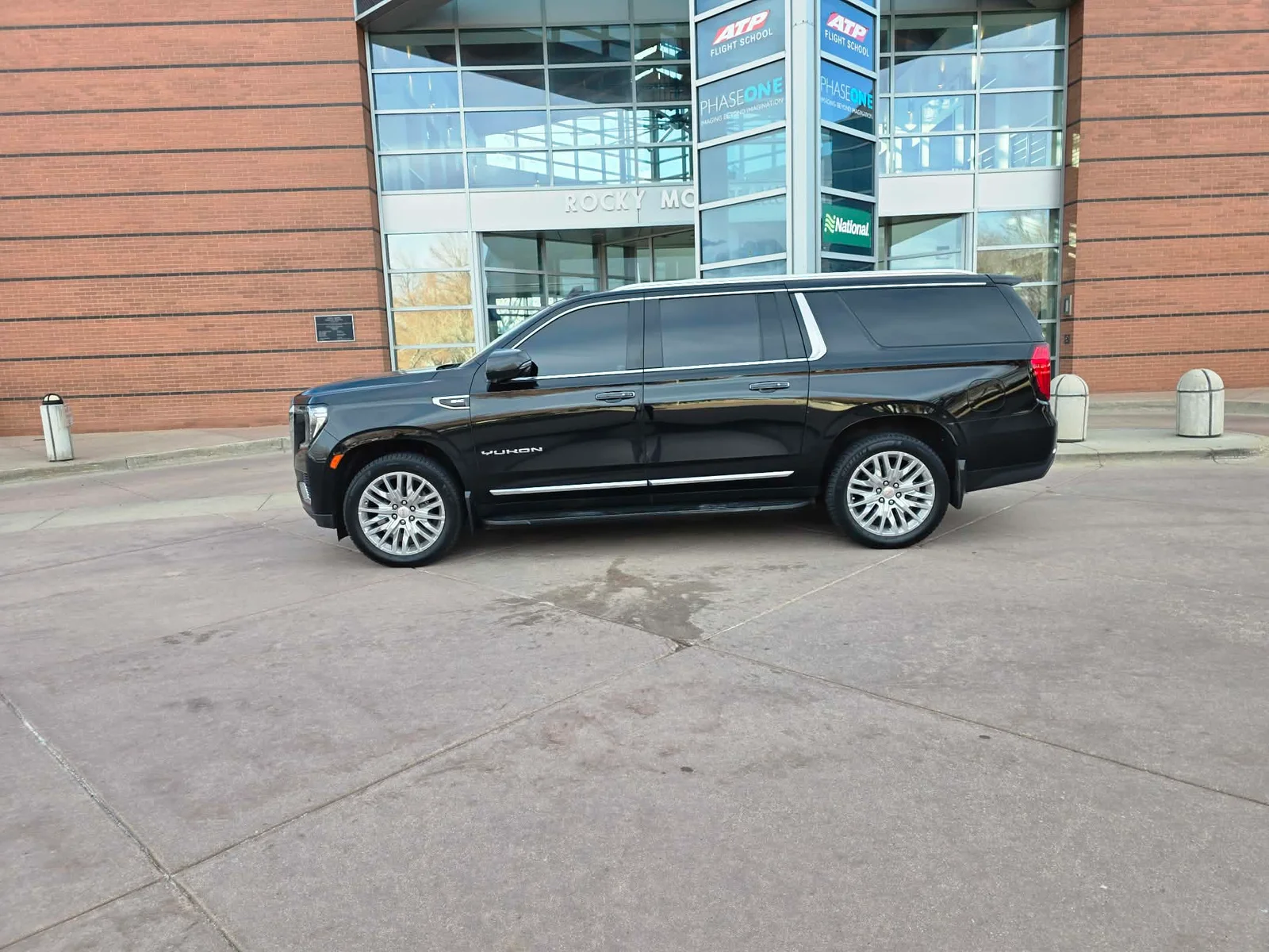 Black GMC Yukon XL outside a Centennial-area private aviation terminal